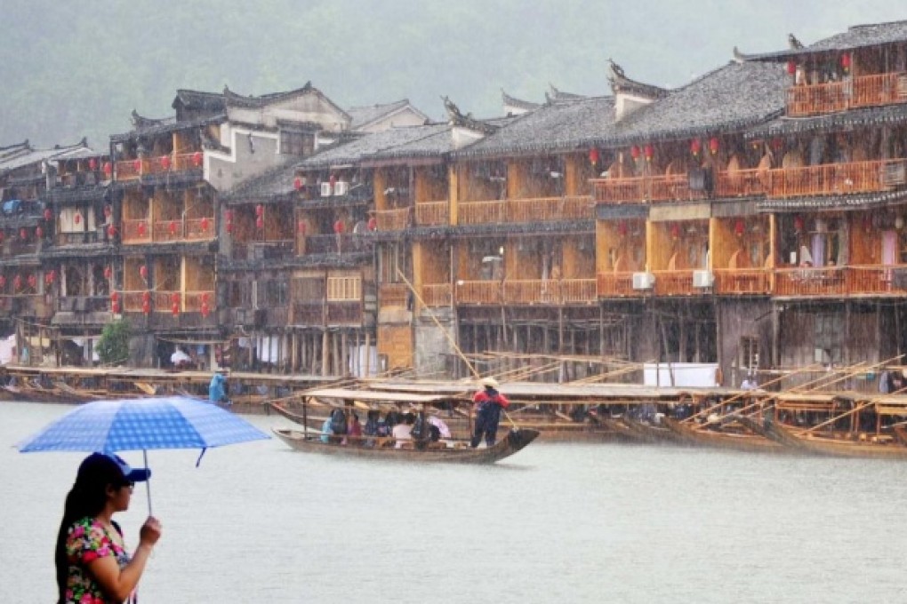 A visitor takes in the scenic Tuo River near the ancient town of Fenghuang in Hunan province. Photo: Xinhua