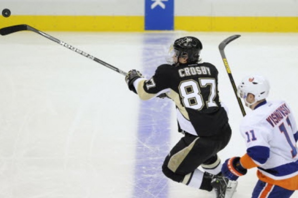 Pittsburgh Penguins' Sidney Crosby (87) juggles the puck past New York Islanders' Lubomir Visnovsky in the third period of their Stanley Cup playoffs Eastern Conference quarter-final game in Pittsburgh, Pennsylvania. Photo: Reuters