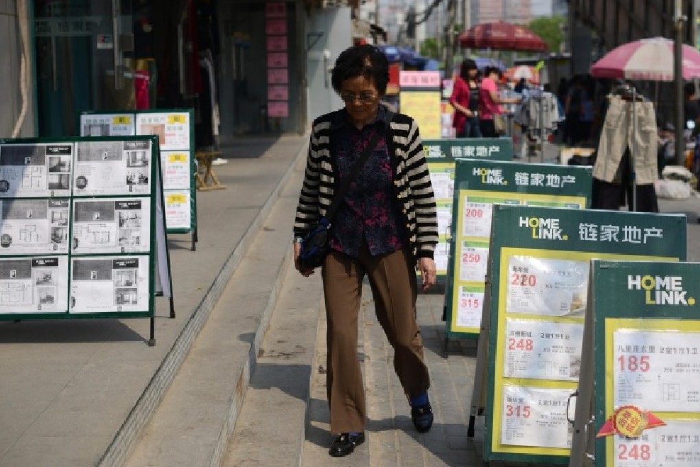 Property advertising boards clutter a sidewalk in Beijing as homes put on the market find few takers in the mainland capital city. Photo: AFP