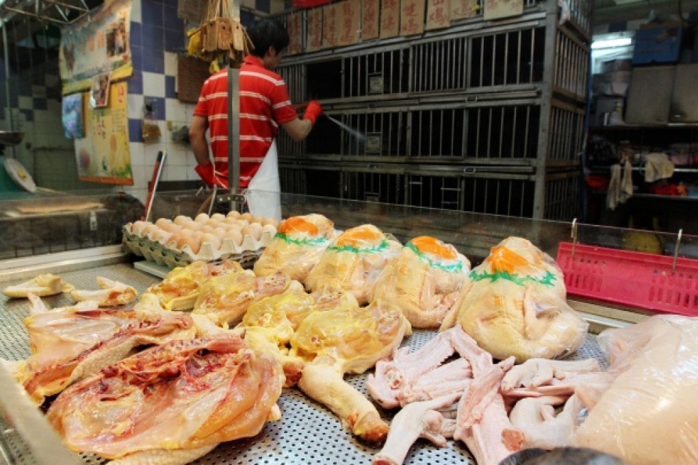 A worker at a stall selling chickens cleans cages. Photo: Felix Wong