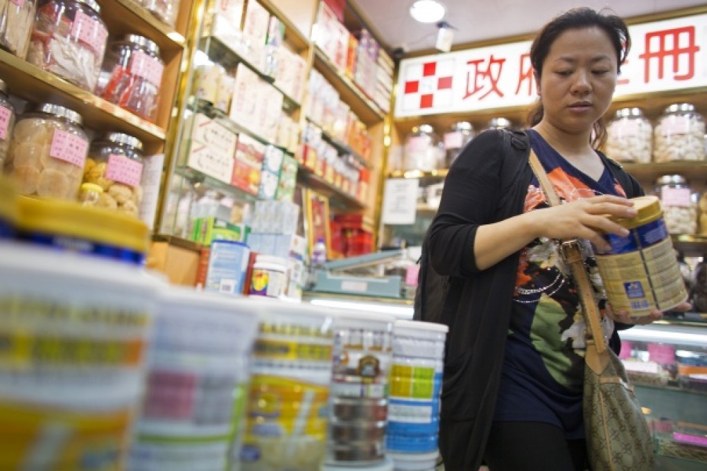 A shopper browses cans of baby formula displayed in a pharmacy in Hong Kong. Few mainlanders trust the Chinese study that showed domestic infant formula is safe. Photo: Bloomberg