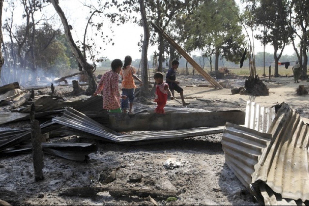 Children walk among debris of damaged buildings following fresh anti-Muslim violence. Photo: AP