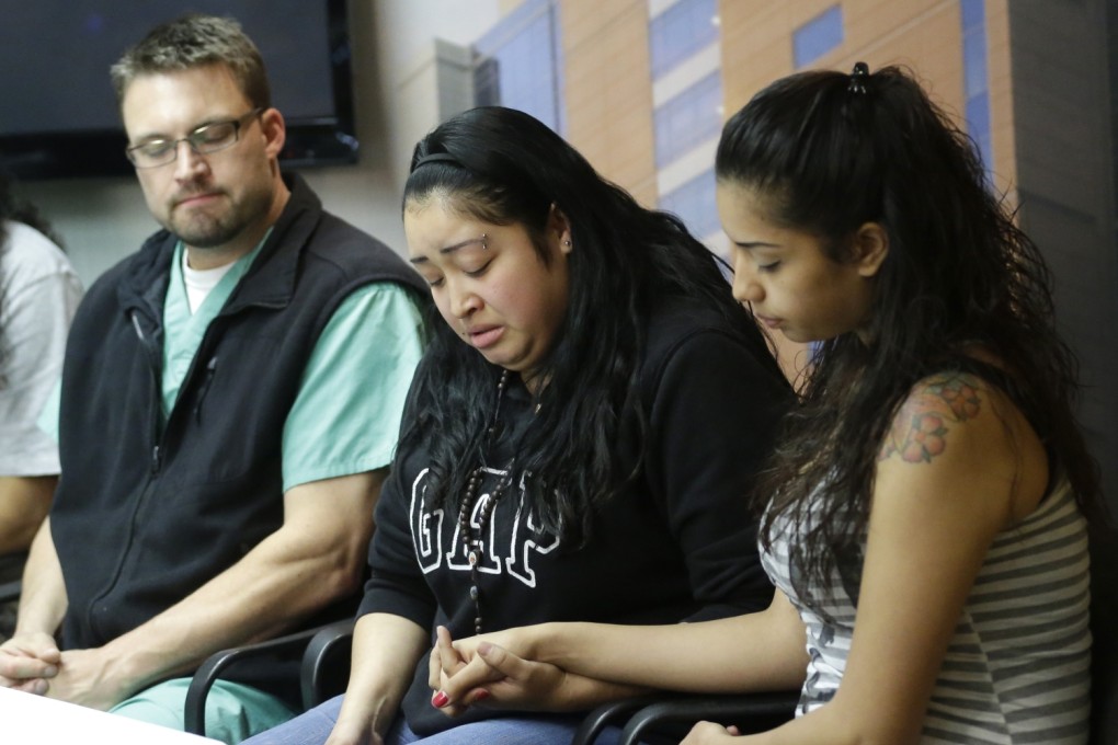 Johana Portillo, centre, and her sister Ana Portillo hold hands while Dr Shawn Smith looks on during a news conference Thursday at Intermountain Medical Center, in Murray, Utah. Photo: AP