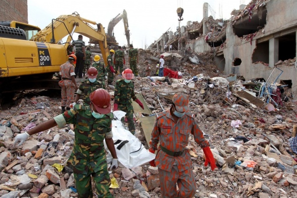 Members of the Bangladeshi Army and fire fighters carry the body of a garment worker as heavy equipment is brought in to remove debris following an eight-storey building collapse in Dhaka. Photo: AFP