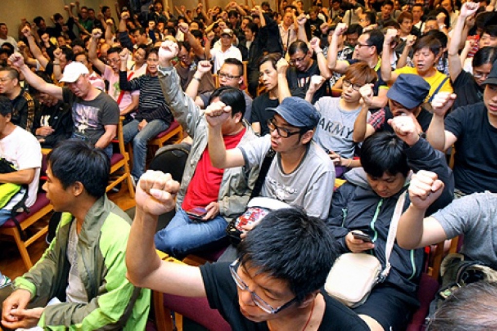 Hundreds of striking dock workers vote in favour of accepting the pay offer at a meeting in Wan Chai yesterday. Photo: David Wong