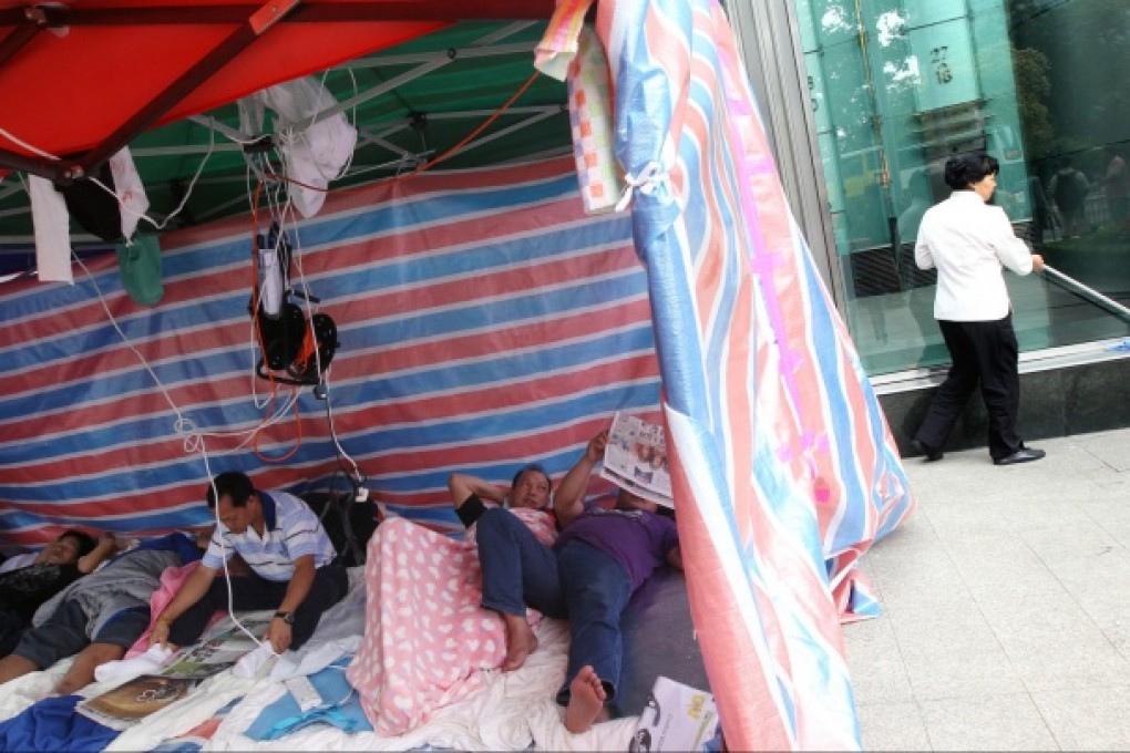 A small group still camps out at the Cheung Kong Center in Central yesterday. Photo: David Wong