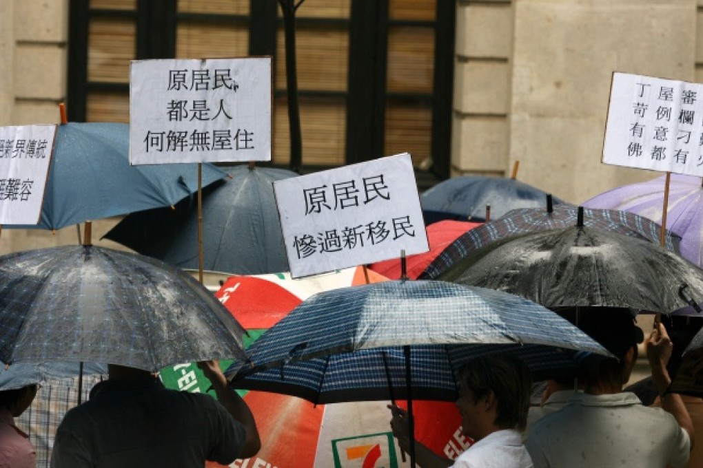 More than 100 angry New Territories indigenous residents of the New Territories hold their umbrellas under the rain and protest outside Legco Building about the small-house policy, Central. Photo: Martin Chan
