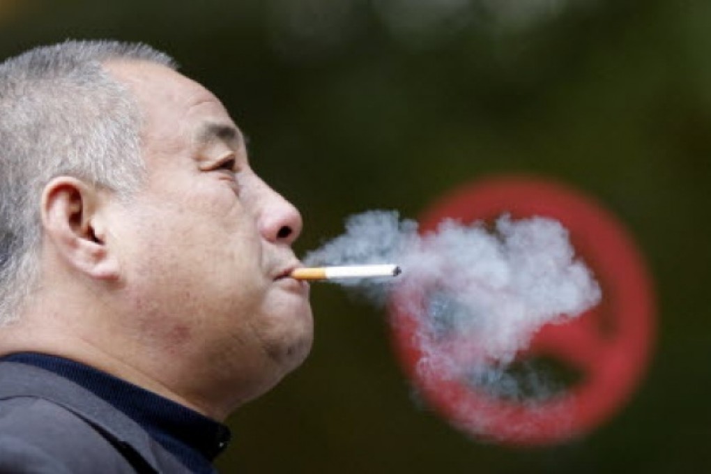 A man smokes next to a "No Smoking" sign in downtown Shanghai. US doctors are advising smokers to have CT screening for lung cancer. Photo: Reuters