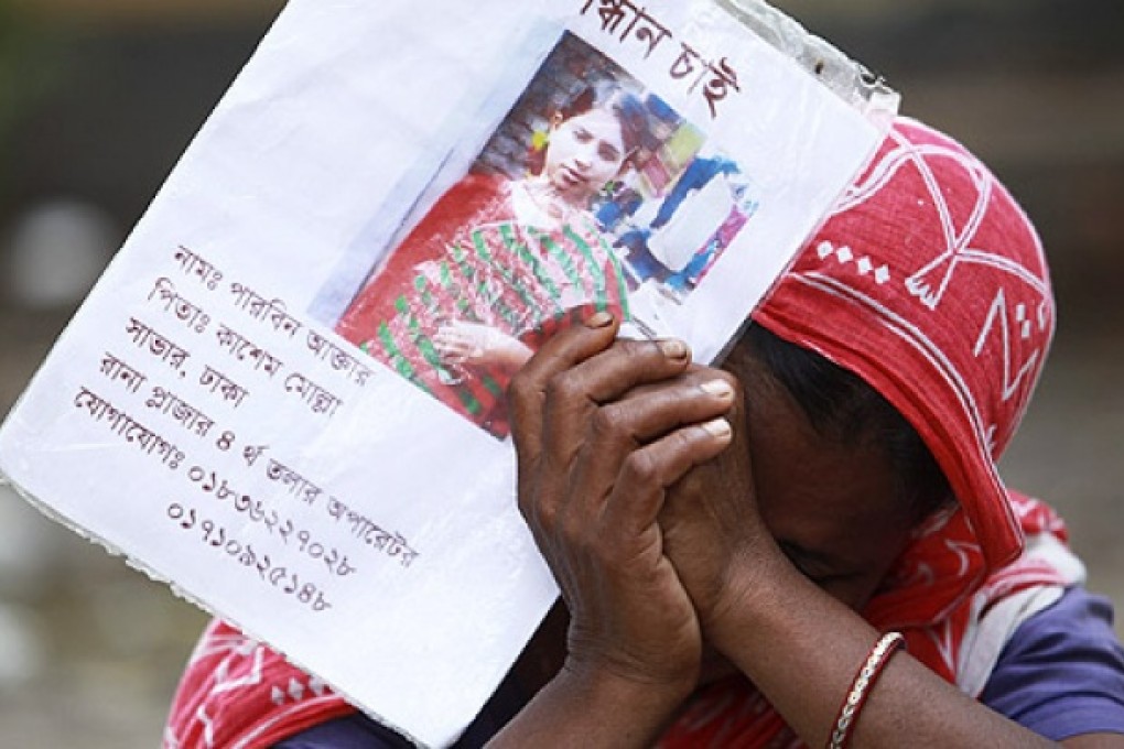 A woman cries holding the photo of her missing daughter on the thirteenth day of the Rana Plaza building collapse, in Savar, Dhaka, on Wednesday. Photo: EPA