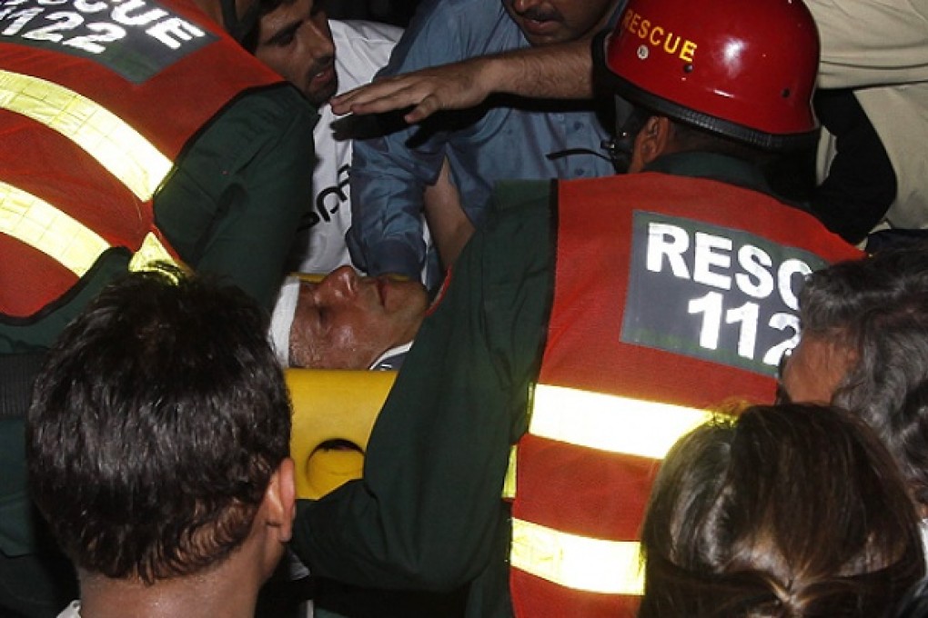 Rescue workers carry injured Pakistani politician after he fell from a makeshift elevator during his election campaign rally in Lahore. Photo: Reuters