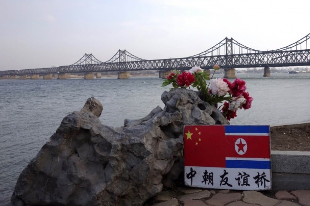 A sign displaying the Chinese and North Korean flags next to the Sino-Korean Friendship Bridge which leads to North Korea, Dandong, Liaoning, April 10,2013. Photo: AFP