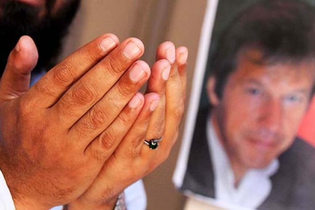 A supporter of Imran Khan prays for his recovery after he sustained head injuries in an accident, in Peshawar, on Wednesday. Photo: EPA