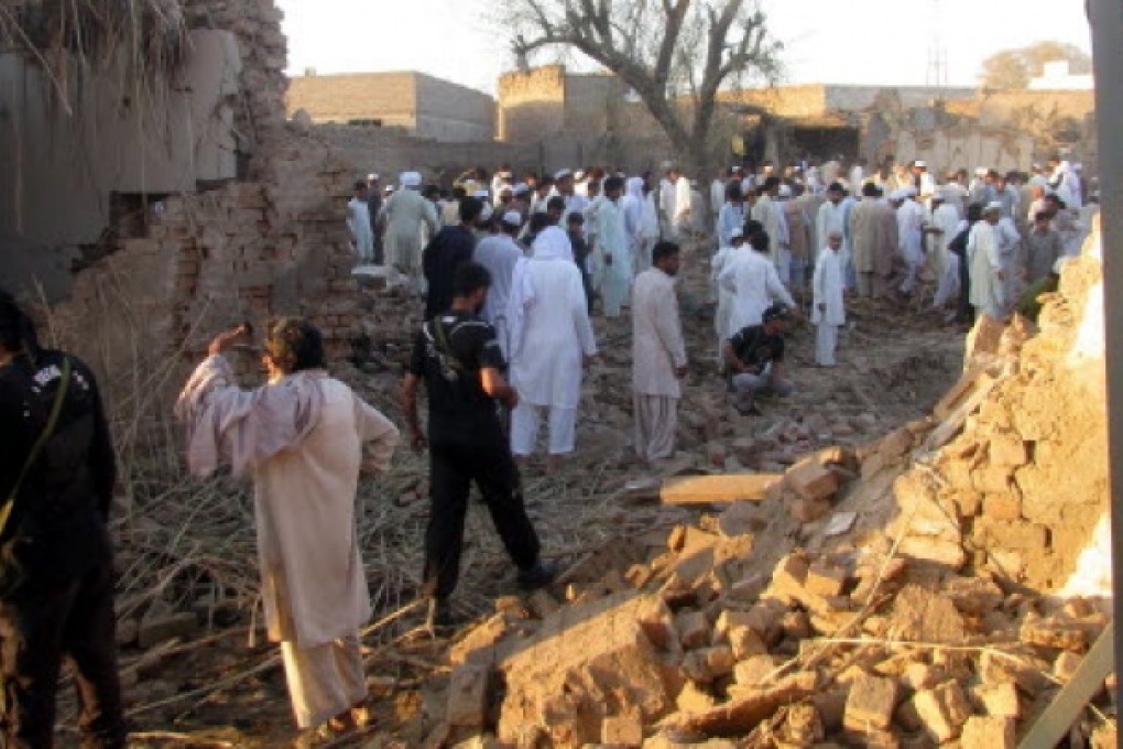 Pakistani security officials inspect the damage caused by a suicide bomb attack that targeted a police station in Bannu on Wednesday. Photo: AFP