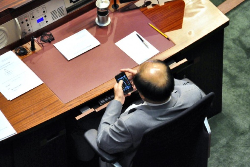 Eddie Ng is seen checking his smartphone. Photo: SCMP