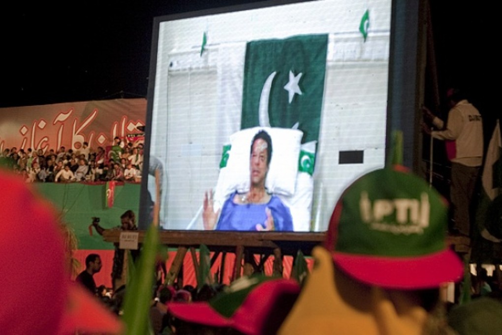 Imran Khan addresses a campaign rally in Islamabad via a video link from his hospital bed. Photo: AP