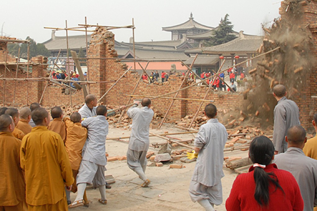 Monks pull down a wall built by a developer in front of Famen Temple, in protest against rapid commercialisation in 2009. Photo: SCMP Pictures