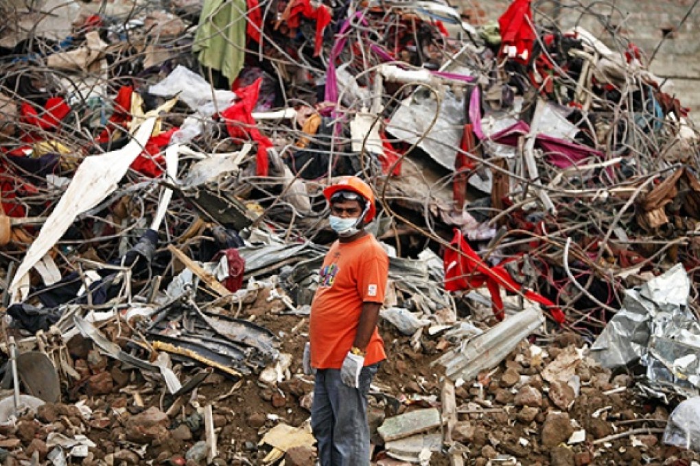 A Bangladeshi rescuer stands amid the rubble of a garment factory building that collapsed on April 24 as they continue searching for bodies in Savar, near Dhaka, on Sunday. Photo: AP