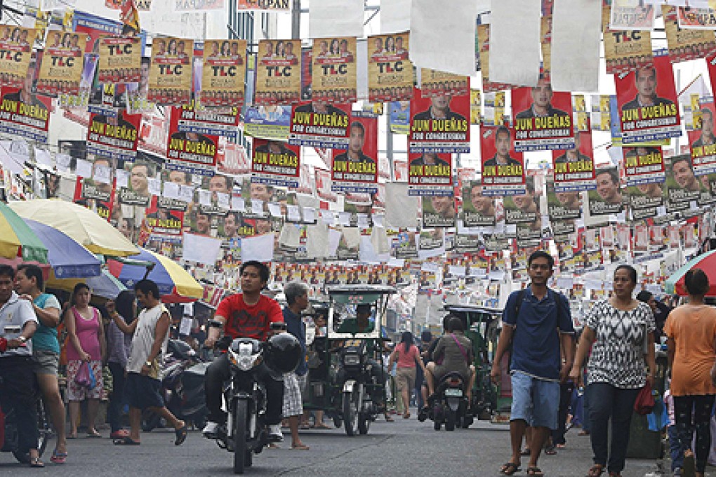 Election posters for the midterm elections hang along a street in Manila. Photo: Reuters