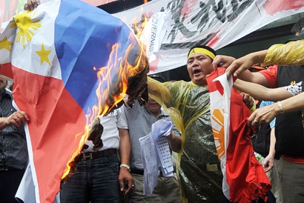 Angry Taiwanese fishermen set fire to Filipino flags during a protest in Taipei on Monday against the shooting to death of a local fisherman by Philippine coastguards. Photo: AFP
