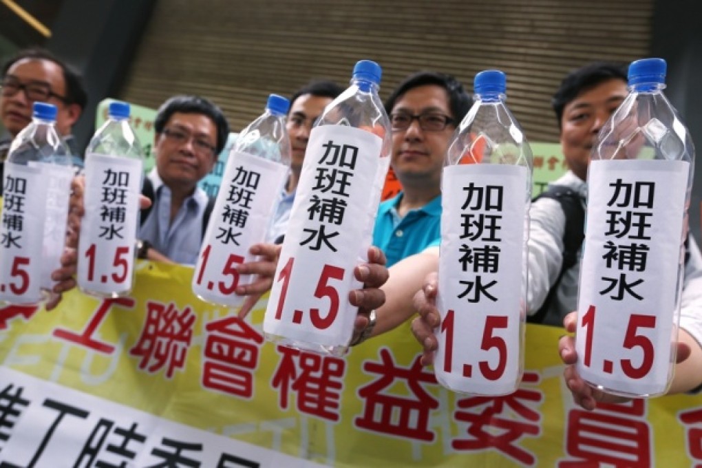 Unionists protest outside where the Standard Working Hours Committee was meeting. Photo: Sam Tsang