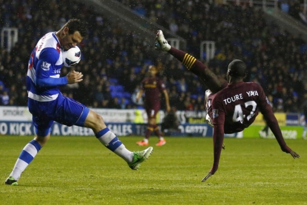 Reading's Sean Morrison blocks a shot from Manchester City's Yaya Toure. Photo: Reuters