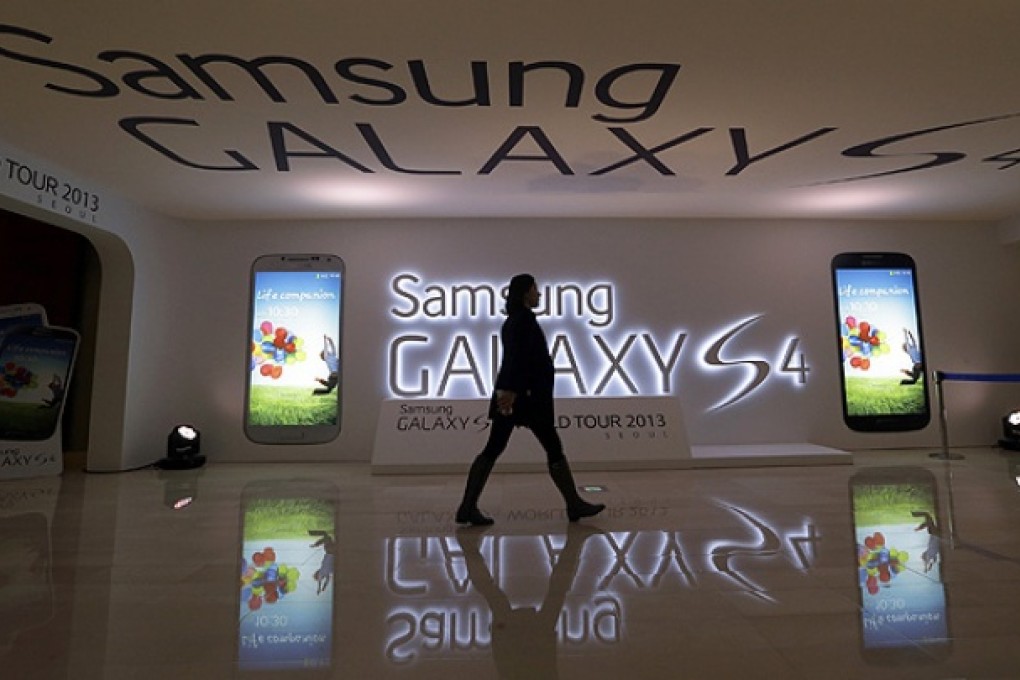 A woman walks by an ad for Samsung 's Galaxy S4 smartphone in Seoul. Photo: AP