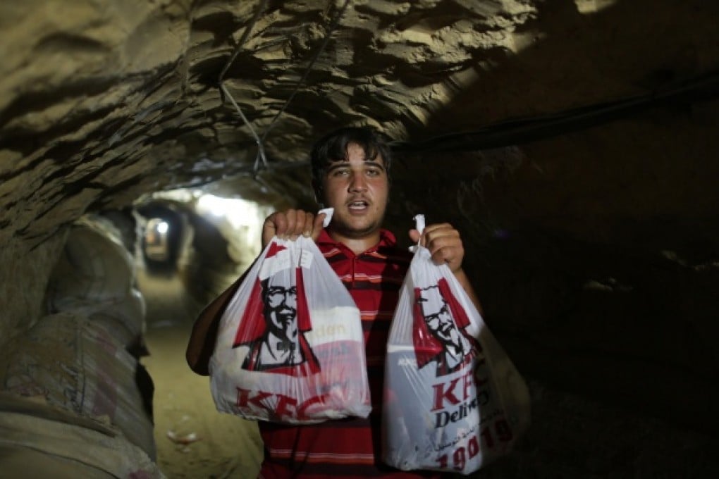 A man holds KFC food in an underground tunnel beneath the Gaza-Egypt border in the southern Gaza Strip city of Rafah. Photo: Xinhua