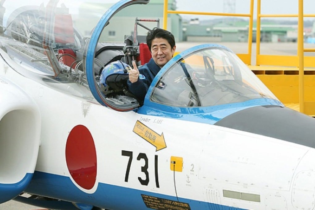 Japanese Prime Minister Shinzo Abe poses in a T-4 military training plane on Sunday. Photo: AFP