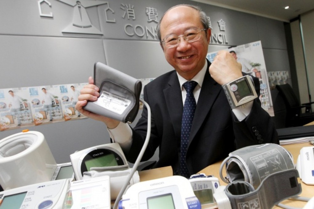 The Consumer Council's publicity and community relations committee chairman Michael Hui King-man shows a range of electronic blood pressure monitors. Photo: May Tse