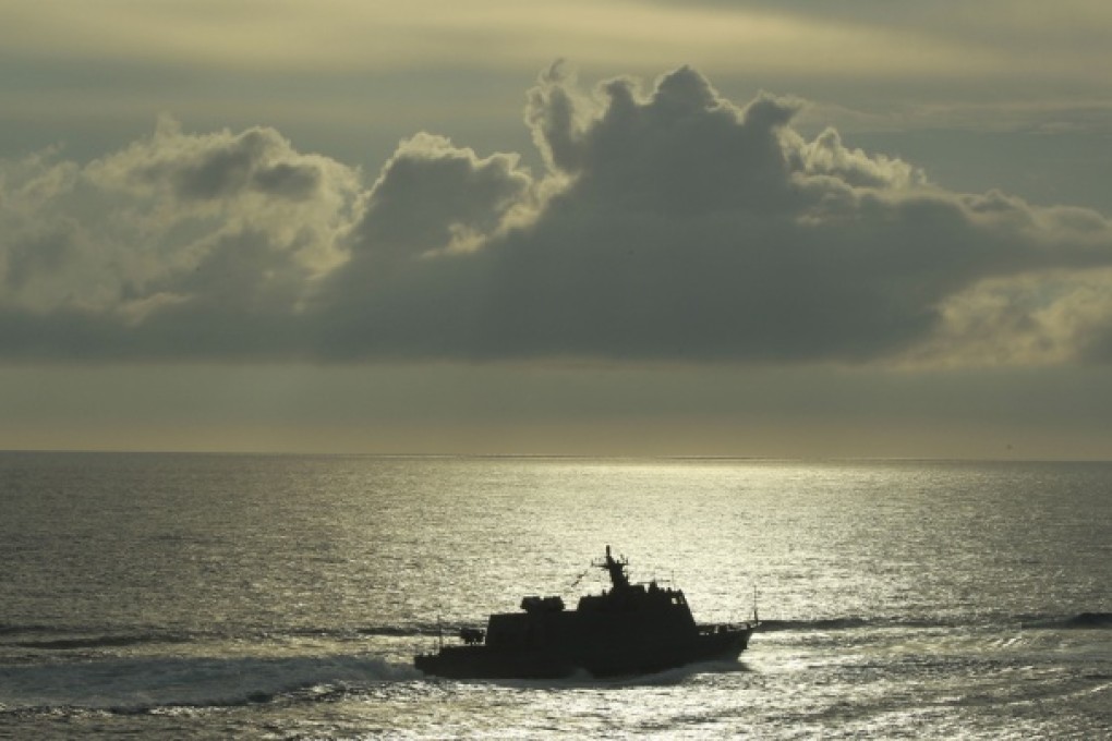 A Taiwanese fast attack cruiser is silhouetted against the sunset during exercises off of Kaohsiung, Taiwan, May 15, 2013. Photo: AP