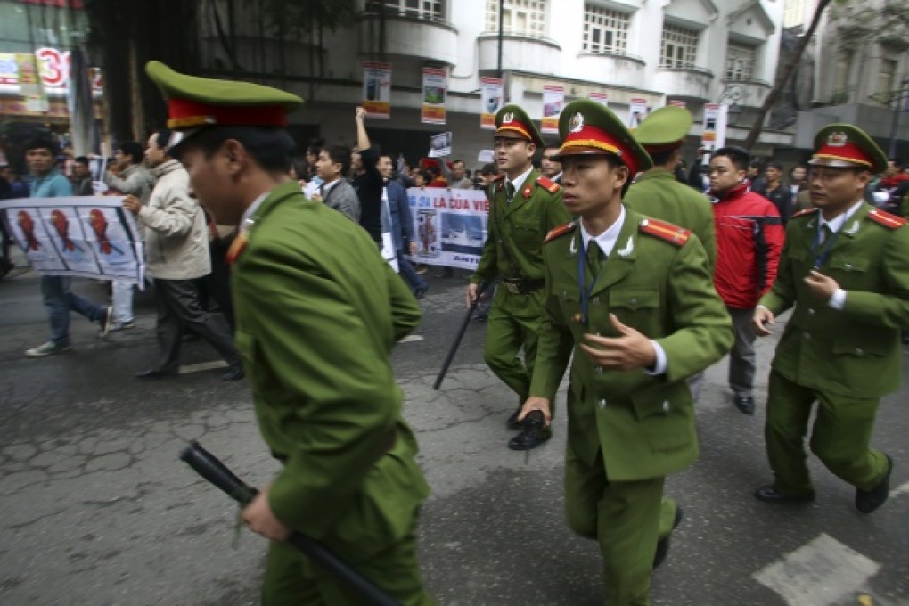 Police officers run to block protesters marching through Hanoi in a demonstration against Beijing''s claims in the South China Sea, Dec. 9, 2012. Photo: AP