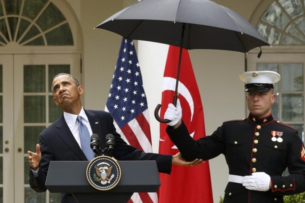 Barack Obama checks to see if he still needs an umbrella during the news conference with Turkey's Recep Tayyip Erdogan. Photo: Reuters