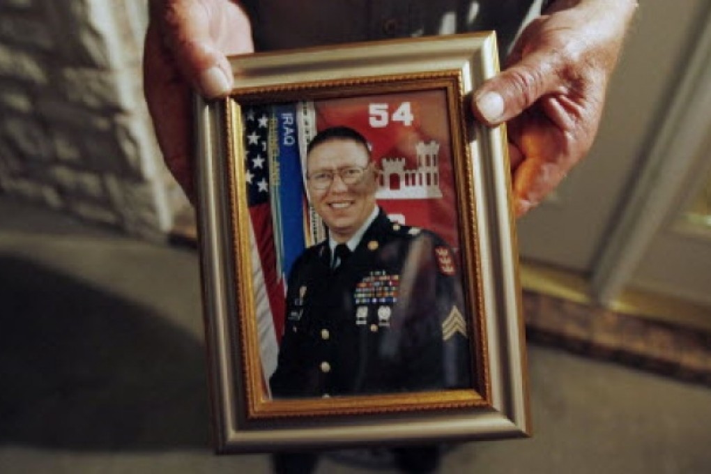 Wilburn Russell, 73, displays a portrait of his son, Sergeant John M. Russell. Photo: Reuters