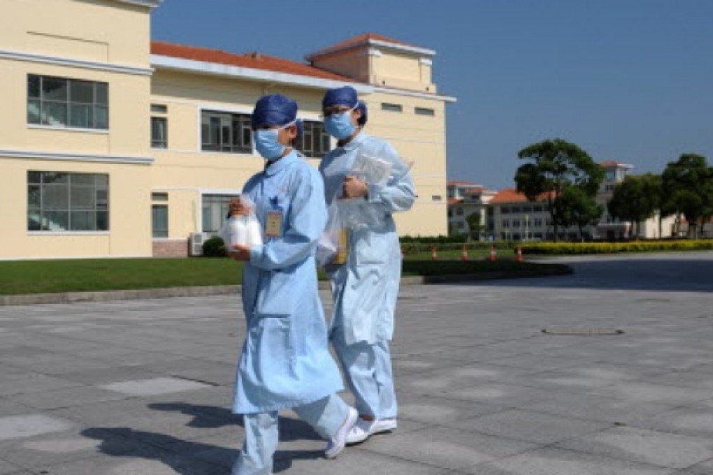 Two nurses walk in front of building A3 at an isolation hospital in southwest Shanghai. Photo: AFP