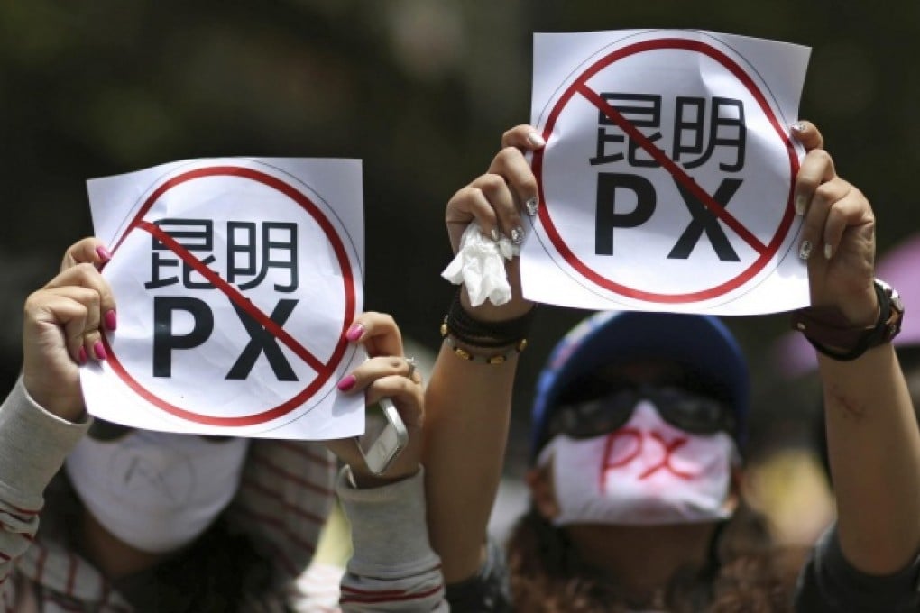 Demonstrators display posters reading "Kunming PX" in a rally against a planned paraxylene plant.