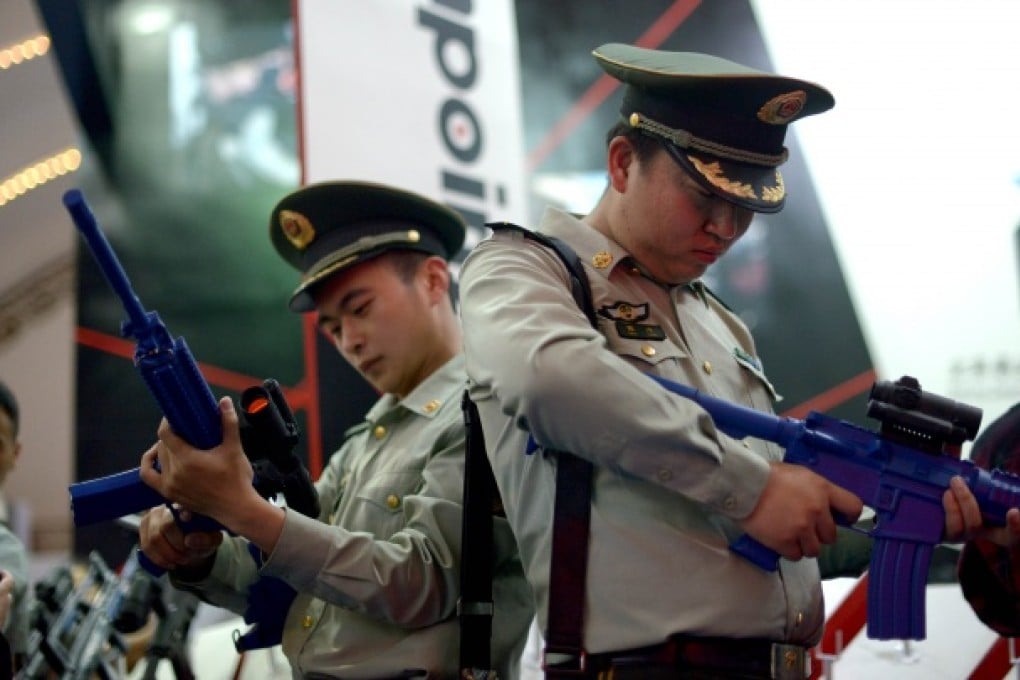 Two Chinese paramilitary policemen test telescopic sights fitted on dummy guns at the China International Exhibition and Symposium on Police Equipment and Anti-Terrorism Technology and Equipment (CIPATE) in Beijing on May 15, 2013. Photo: AFP
