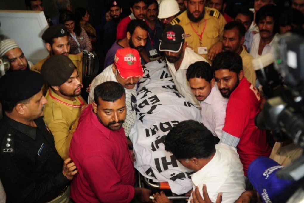 Rescuers carry the dead body of Zohra Hussain, vice-president of the women's wing of Pakistan Tehreek-e-Insaf party of Sindh. Photo: AFP