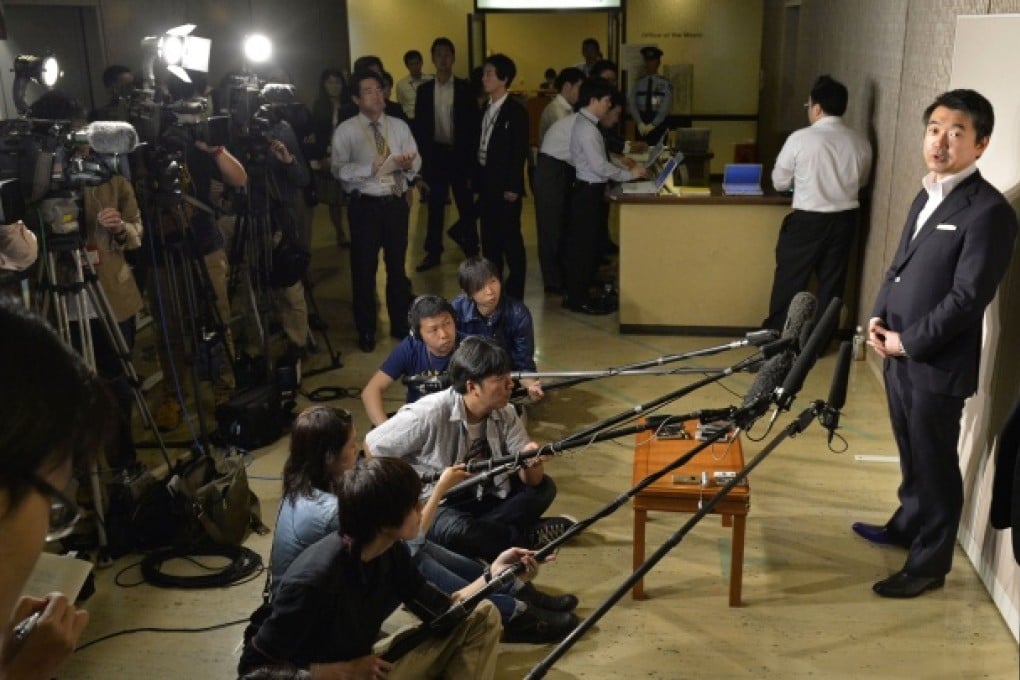 Osaka Mayor Toru Hashimoto, right, a founder and co-leader of the Japan Restoration Party, speaks to journalists in Osaka, Japan. Photo: AP