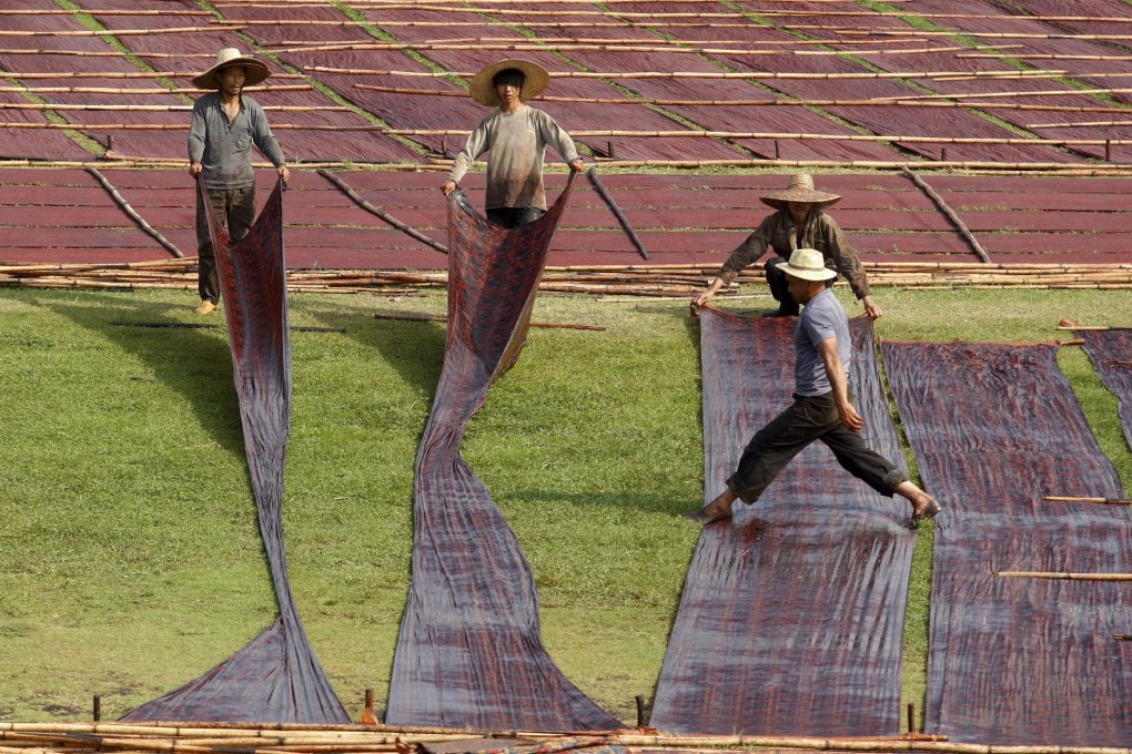 Panels of handmade gambiered silk are laid out to dry in Guangdong province's Shunde district. Photo: EPA