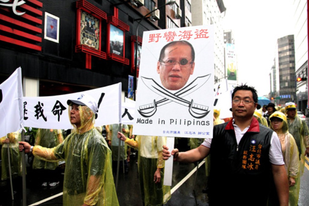 Hundreds of Taiwan fishermen, holding a portrait of Philippine President Benigno Aquino, march to the Philippine trade office in Tapei in protest last week. Photo: EPA