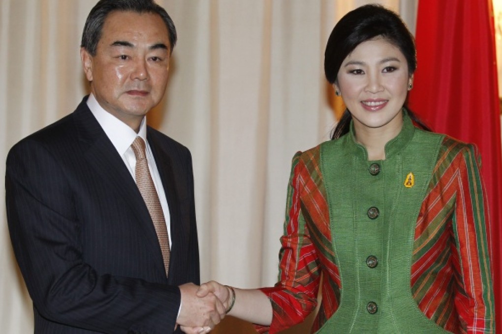 Chinese Minister of Foreign Affairs Wang Yi (left) is greeted by Thai Prime Minister Yingluck Shinawatra during a meeting at Government House in Bangkok. Photo: EPA