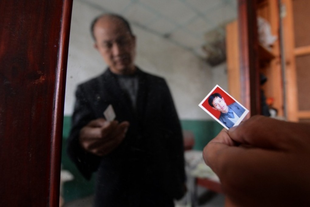 Zhang Gaoping, a 48-year-old man acquitted after 10 years in jail, shows his photo taken at the age of 37 at his former residence in Qichuan Village. Photo: Xinhua