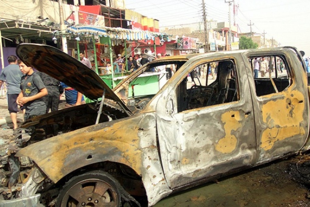 A damaged truck is seen after a car bomb attack near a popular market in Basra. Photo: EPA