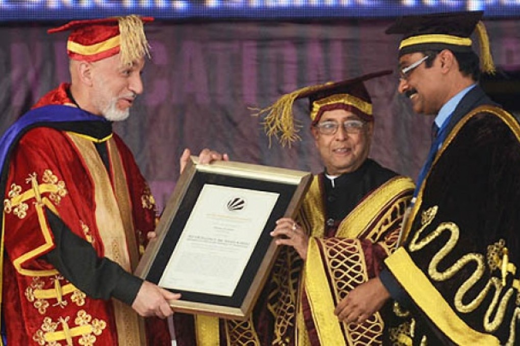 Indian President Pranab Mukherjee (centre) and Lovely Professional University chancellor Ashok Mittal (right) present an honorary degree to Afghanistan President Hamid Karzai on Monday. Photo: AFP