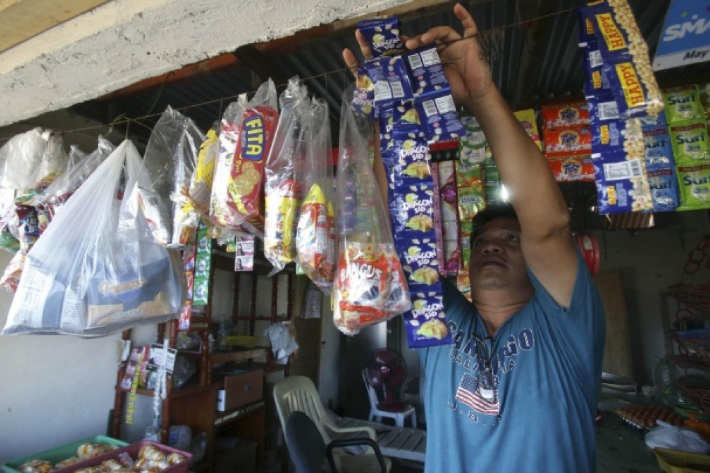 Fish trader Joey Legazpi tends to his store in Infanta. Photo: AP