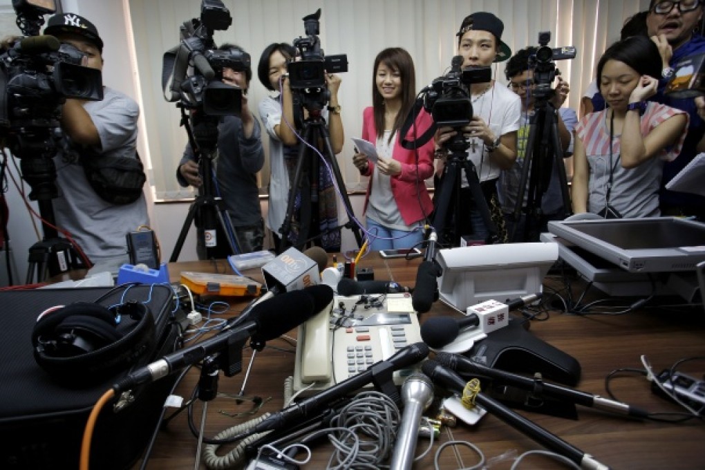 Reporters crowd around a speakerphone as they listen to the transgender woman, identified only as W, after she won a legal ruling at Hong Kong's top court allowing her to marry. Photo: AP