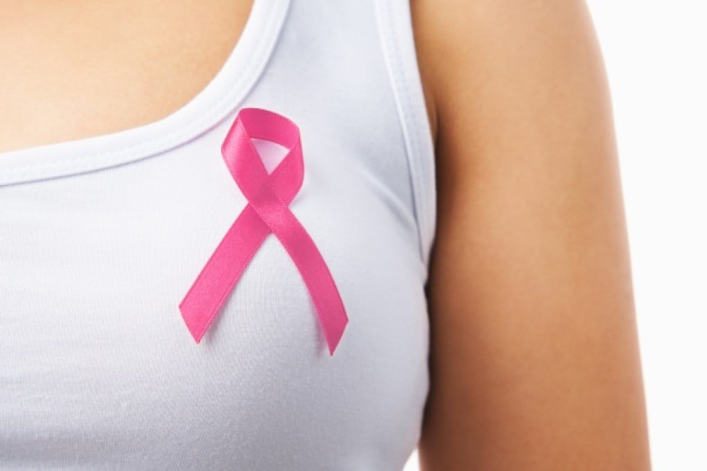 Close up of pink badge on woman chest to support breast cancer cause. Photo: Shutterstock