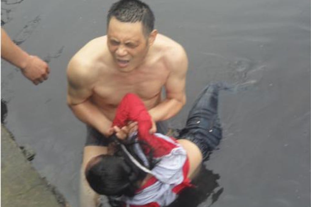 Zhang Guangcong rescues a girl from a polluted river. Photo: SCMP Pictures