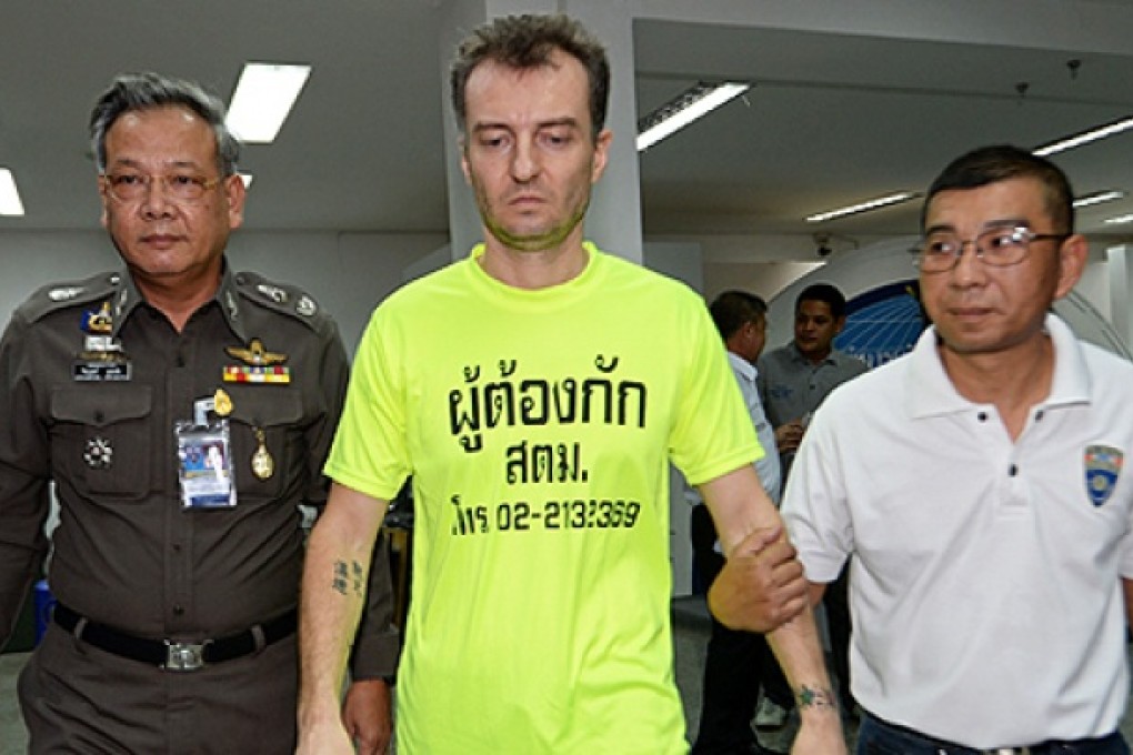 Suspected fraudster, Raccagni Stefano of Italy (centre), 38, is escorted by Thai police during a press conference at the Thai immigration bureau in Bangkok on Thursday. Photo: AFP