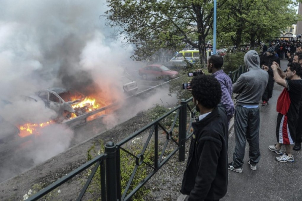 Cars burn in the Stockholm suburb of Rinkeby on Wednesday after youths rioted for the fourth night in a row. Photo: EPA
